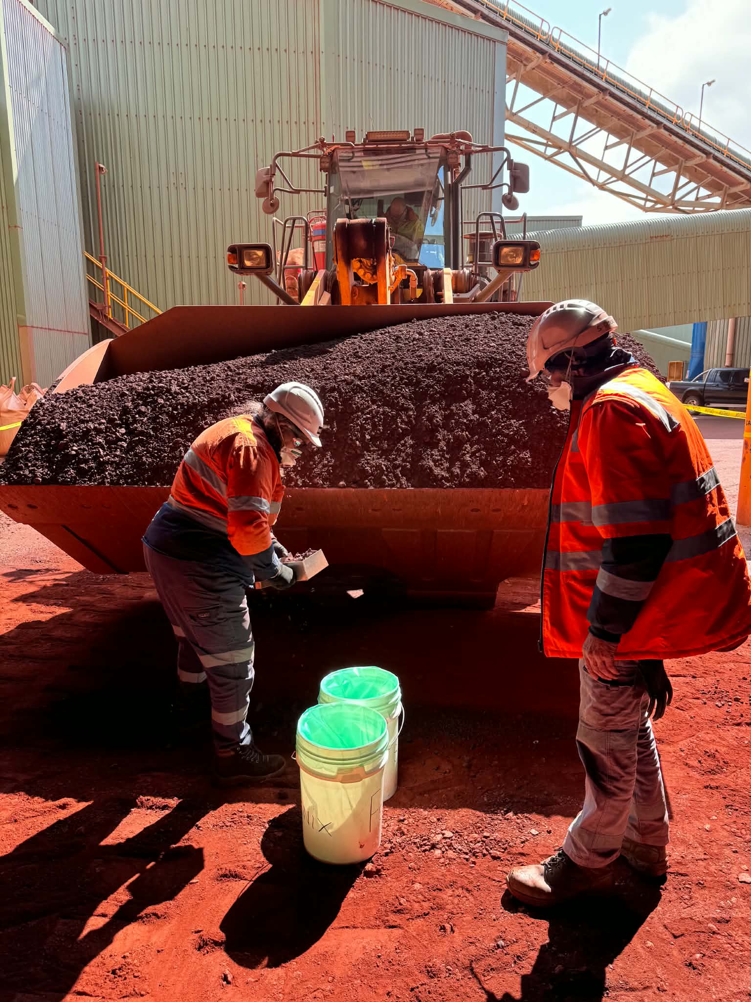 Reliance personnel sampling bulk material beside mobile plant